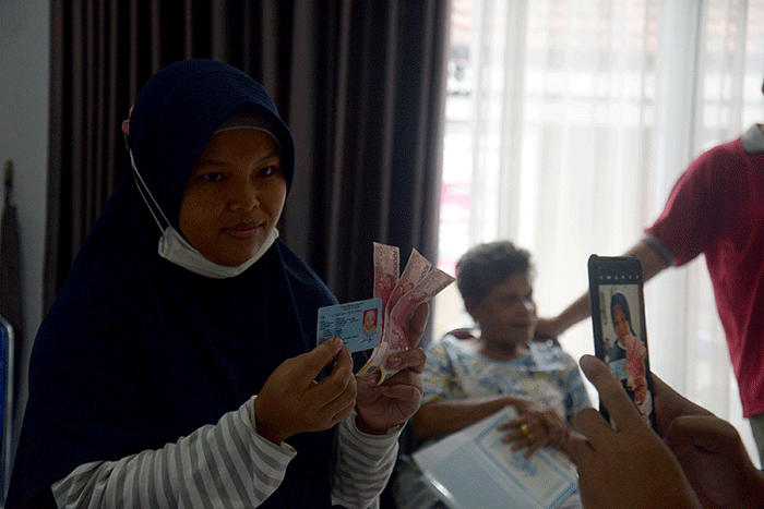 Warga menunjukan uang senilai Rp 300.000 saat pembagian Bantuan Langsung Tunai (BLT) subsidi Bahan Bakar Minyak (BBM) di kawasan Gambir, Jakarta.