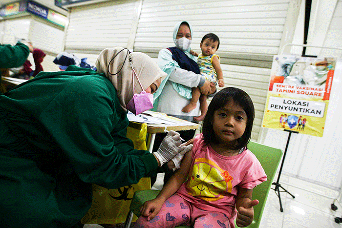 Petugas medis saat memberikan suntikan vaksin campak-rubella untuk Anak dalam program Bulan Imunisasi Anak Nasional (BIAN) di Mal Tamini Square.