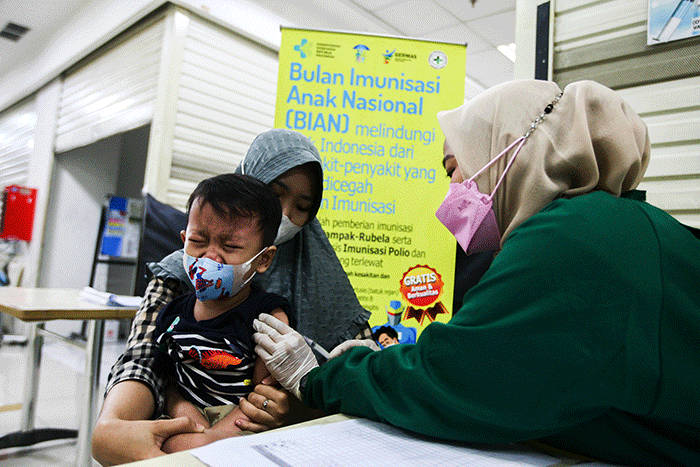 Petugas medis saat memberikan suntikan vaksin campak-rubella untuk Anak dalam program Bulan Imunisasi Anak Nasional (BIAN) di Mal Tamini Square.