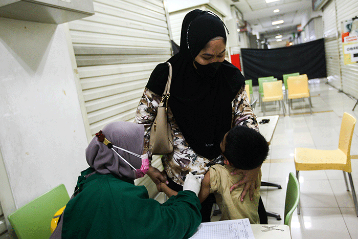 Petugas medis saat memberikan suntikan vaksin campak-rubella untuk Anak dalam program Bulan Imunisasi Anak Nasional (BIAN) di Mal Tamini Square.
