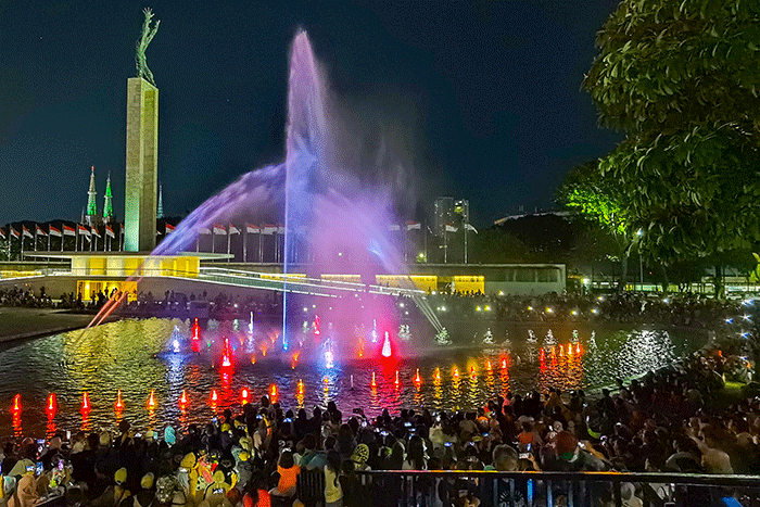 Warga memenuhi pertunjukan air mancur dengan lampu warna-warni di Taman Lapangan Banteng, Jakarta, Minggu (4/9/2022).
