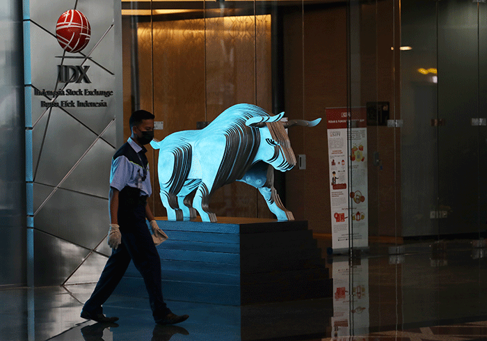 Pekerja melintas di depan layar indeks harga saham gabungan (IHSG) di Gedung Bursa Efek Indonesia, Jakarta, Rabu (7/9/2022).