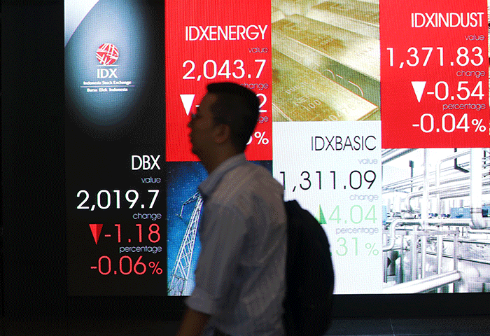Pekerja melintas di depan layar indeks harga saham gabungan (IHSG) di Gedung Bursa Efek Indonesia, Jakarta, Rabu (7/9/2022).