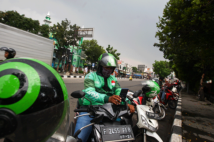 Pengemudi ojek online (ojol) saat menunggu kedatangan penumpang di kawasan Pinang Ranti, Jakarta Timur, Rabu (7/9/2022).