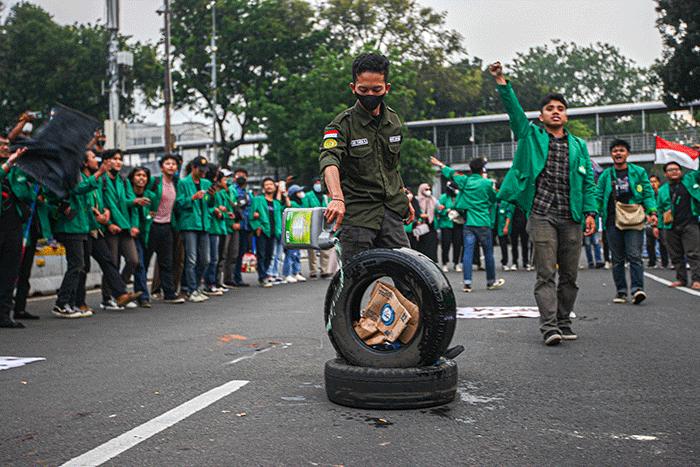 Mahasiswa melompati api dari bakaran ban bekas saat aksi demo tolak kenaikan harga BBM di kawasan Patung Kuda, Jakarta, Jumat (9/9/2022).