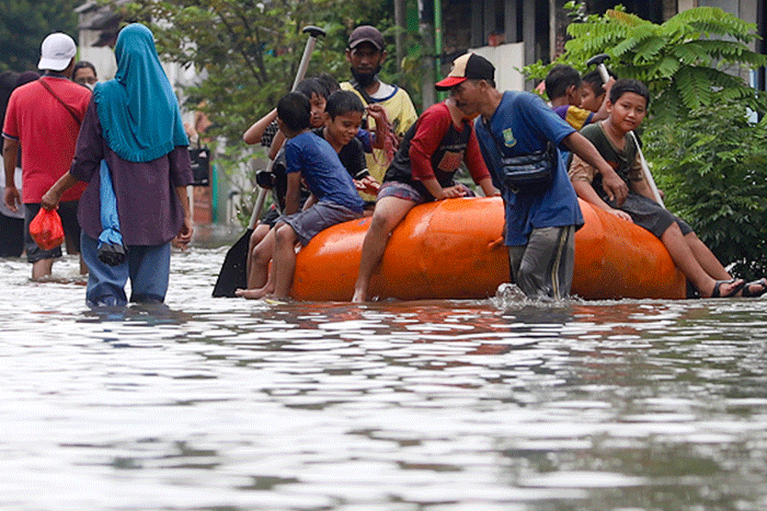 Warga melintasi banjir di permukiman di Kawasan Ciledug Indah, Tangerang, Minggu (11/9/2022).