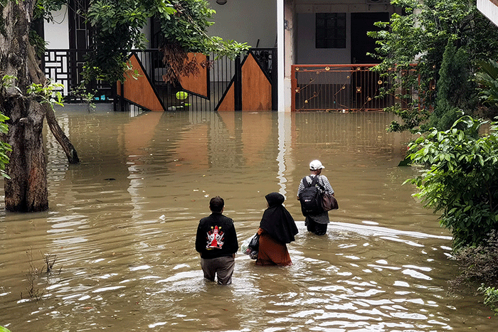Warga melintasi banjir di permukiman di Kawasan Ciledug Indah, Tangerang, Minggu (11/9/2022).