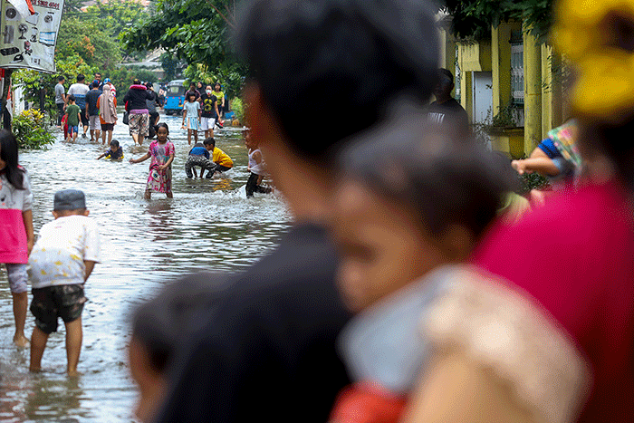 Warga melintasi banjir di permukiman di Kawasan Ciledug Indah, Tangerang, Minggu (11/9/2022).