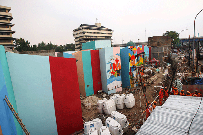 Petugas PPSU membuat mural disalah satu bangunan Kampung Gembira di kawasan Pasar Gembrong, Jakarta Timur, Selasa (13/9/2022).