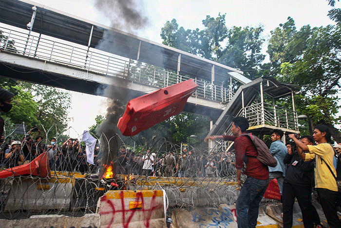 Massa aksi menghindar dari kobaran api saat demo menolak kenaikan BBM di kawasan Patung Kuda, Monas, Jakarta Selasa (13/9/2022).