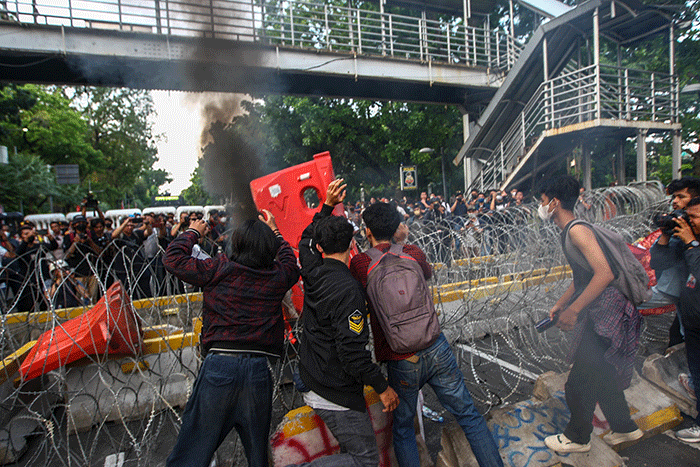 Massa aksi menghindar dari kobaran api saat demo menolak kenaikan BBM di kawasan Patung Kuda, Monas, Jakarta Selasa (13/9/2022).