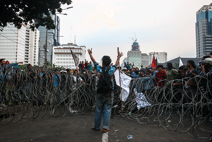 Massa aksi menghindar dari kobaran api saat demo menolak kenaikan BBM di kawasan Patung Kuda, Monas, Jakarta Selasa (13/9/2022).