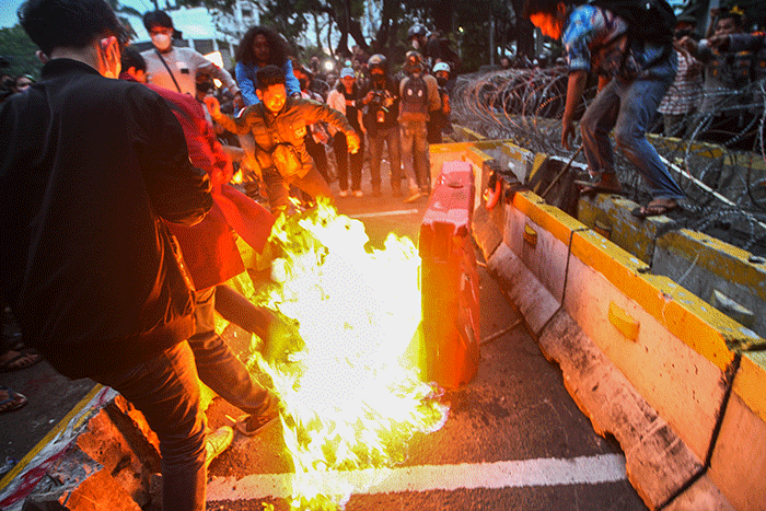 Massa aksi menghindar dari kobaran api saat demo menolak kenaikan BBM di kawasan Patung Kuda, Monas, Jakarta Selasa (13/9/2022).
