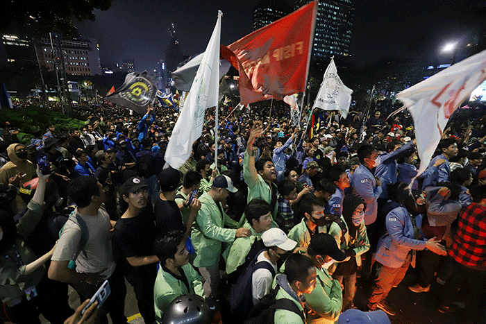 Sejumlah pengunjuk rasa berusaha membakar pembatas jalan saat aksi di kawasan Jalan Medan Merdeka Barat, Jakarta, Selasa (13/9/2022).