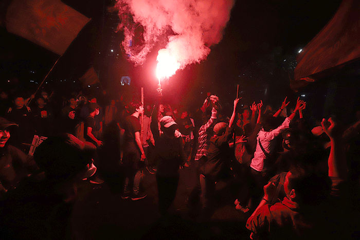 Sejumlah pengunjuk rasa berusaha membakar pembatas jalan saat aksi di kawasan Jalan Medan Merdeka Barat, Jakarta, Selasa (13/9/2022).