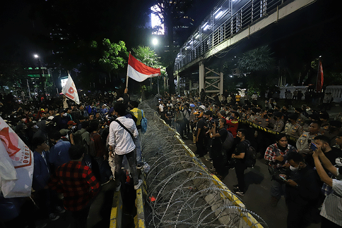 Sejumlah pengunjuk rasa berusaha membakar pembatas jalan saat aksi di kawasan Jalan Medan Merdeka Barat, Jakarta, Selasa (13/9/2022).