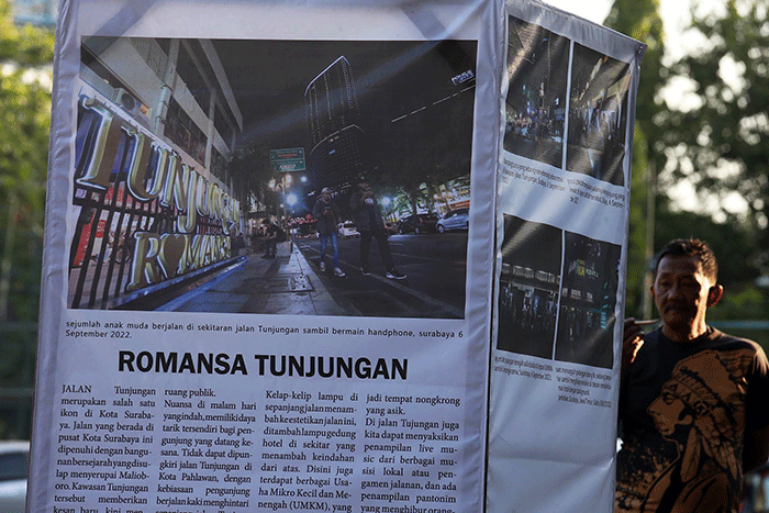 Pengunjung mengamati foto cerita karya Unit Kegiatan Mahasiswa (UKM) Communication Photography Club (CIPHOC).