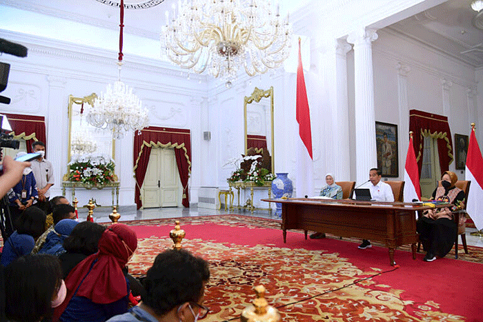 Presiden Joko Widodo (tengah) didampingi Menteri Sosial Tri Rismaharini (kanan) dan Menteri Ketenagakerjaan Ida Fauziyah memberikan keterangan pers.
