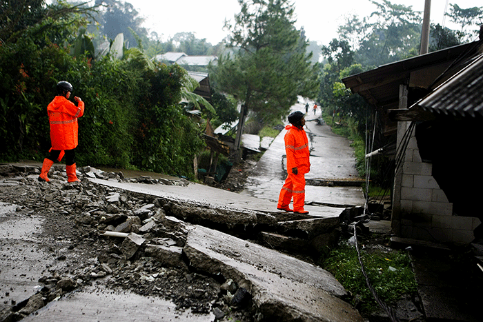 Sejumlah warga melintas di ruas jalan yang rusak akibat bencana tanah bergerak di Desa Bojong Koneng, Bogor, Jawa Barat, Jumat (23/9/2022).