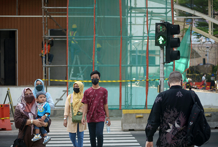 Warga tetap menerapkan protokol kesehatan saat berjalan di kawasan Jalan MH Thamrin, Jakarta Pusat, Jumat (23/9/2022).