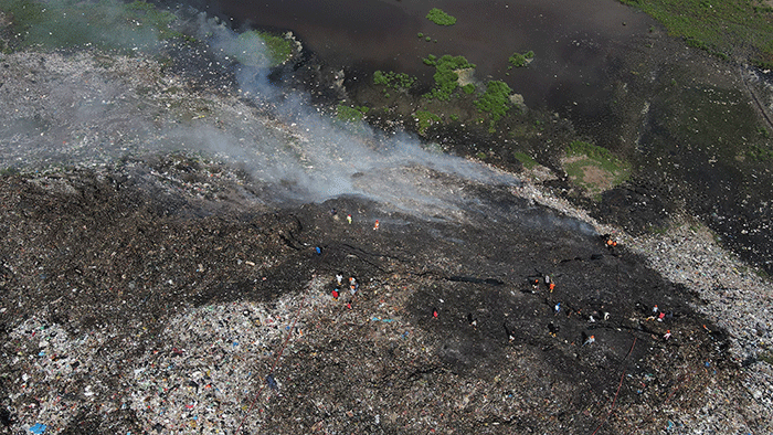Petugas pemadam kebakaran melanjutkan proses pendinginan saat api melalap gunung sampah di Tempat Pembuangan Akhir (TPA) Sampah Tamangapa, Makassar.