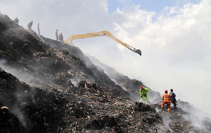 Petugas pemadam kebakaran melanjutkan proses pendinginan saat api melalap gunung sampah di Tempat Pembuangan Akhir (TPA) Sampah Tamangapa, Makassar.