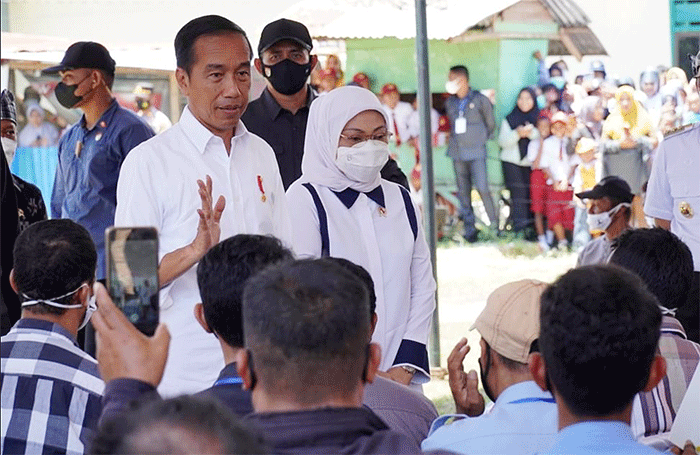 Presiden Joko Widodo didampingi Menteri Ketenagakerjaan Ida Fauziyah (kiri) saat meninjau penyaluran bantuan dari pemerintah kepada masyarakat.