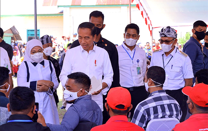 Presiden Joko Widodo didampingi Menteri Ketenagakerjaan Ida Fauziyah (kiri) saat meninjau penyaluran bantuan dari pemerintah kepada masyarakat.