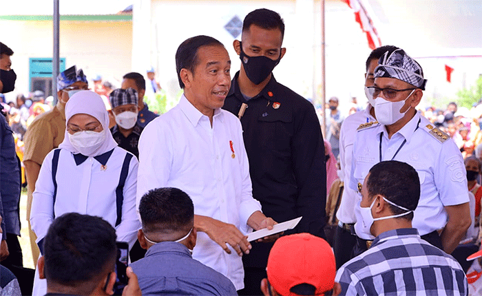 Presiden Joko Widodo didampingi Menteri Ketenagakerjaan Ida Fauziyah (kiri) saat meninjau penyaluran bantuan dari pemerintah kepada masyarakat.