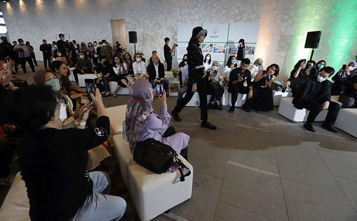 Model memeragakan busana terbaru dari UNIQLO yang dihasilkan dari proses daur ulang dengan teknik recycle dan upcycle di Jakarta, Kamis (29/9/2022).