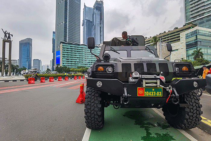 Warga berfoto di depan sejumlah alat utama sistem persenjataan atau alutsista milik TNI yang dipamerkan didepan Istana dan Bundaran Hotel Indonesia.