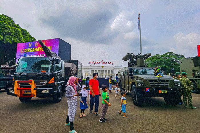 Warga berfoto di depan sejumlah alat utama sistem persenjataan atau alutsista milik TNI yang dipamerkan didepan Istana dan Bundaran Hotel Indonesia.