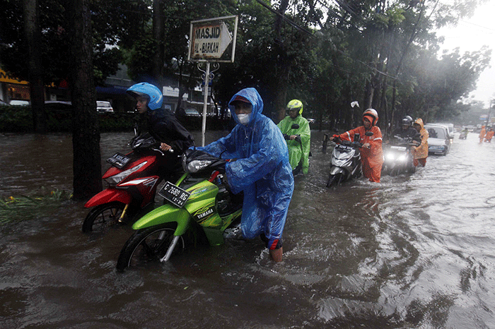 Sejumlah warga mendorong sepeda motornya saat banjir di Taman Cilandak Raya, Lebak Bulus, Jakarta Selatan, Kamis (6/10/2022).