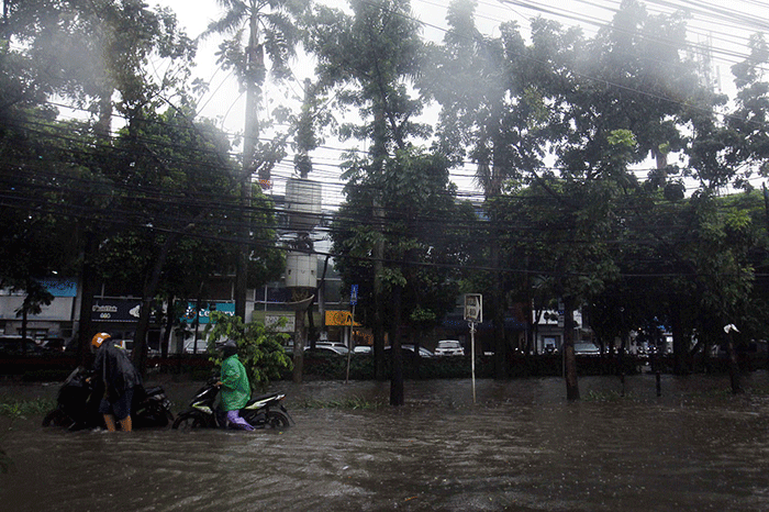 Sejumlah warga mendorong sepeda motornya saat banjir di Taman Cilandak Raya, Lebak Bulus, Jakarta Selatan, Kamis (6/10/2022).