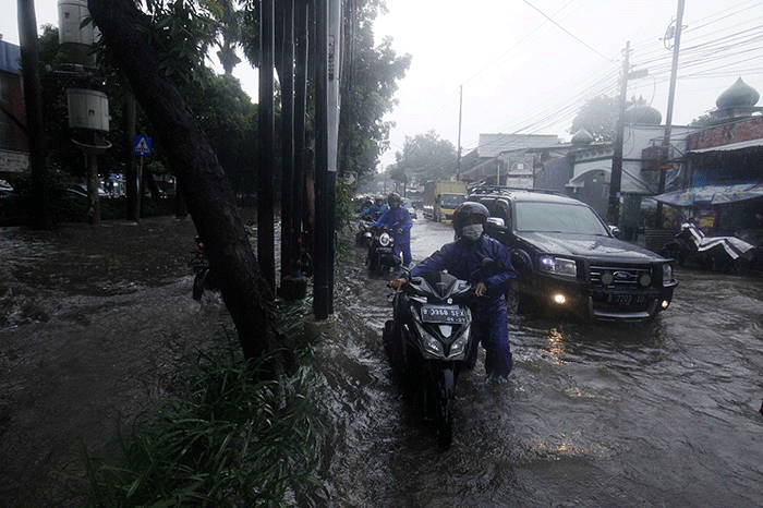 Sejumlah warga mendorong sepeda motornya saat banjir di Taman Cilandak Raya, Lebak Bulus, Jakarta Selatan, Kamis (6/10/2022).