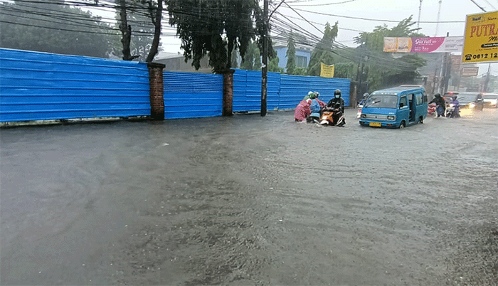 Pengendara menerobos banjir di Jalan Cirendeu Raya, Tangerang Selatan, Banten, Kamis (6/10/2022).