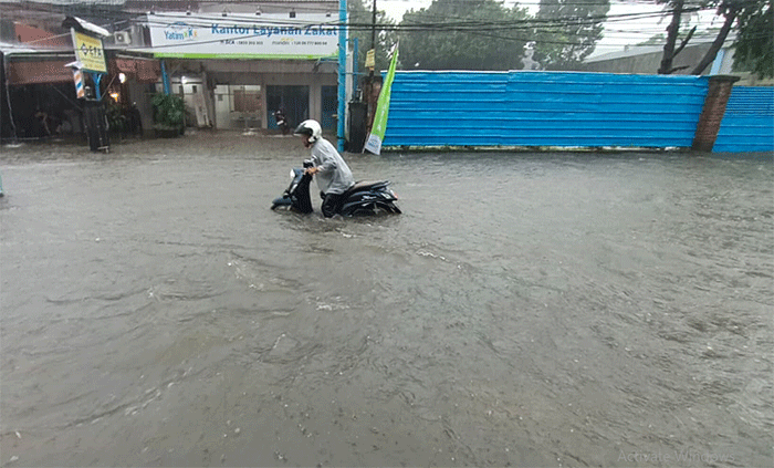 Pengendara menerobos banjir di Jalan Cirendeu Raya, Tangerang Selatan, Banten, Kamis (6/10/2022).