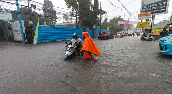 Pengendara menerobos banjir di Jalan Cirendeu Raya, Tangerang Selatan, Banten, Kamis (6/10/2022).