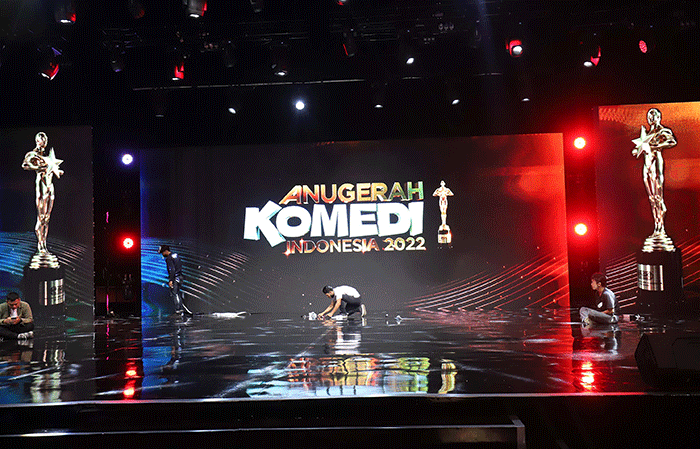 Pekerja menyelesaikan panggung Malam Puncak Anugerah Komedi Indonesia 2022 di Jakarta Concert Hall, Gedung iNews, Jakarta, Jumat (14/10/2022).