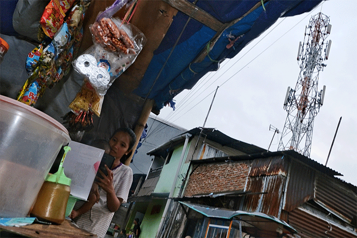 Warga memanfaatkan teknologi smartphone saat beraktivitas di kawasan PT Tower Bersama Infrastructure Tbk (TBIG).