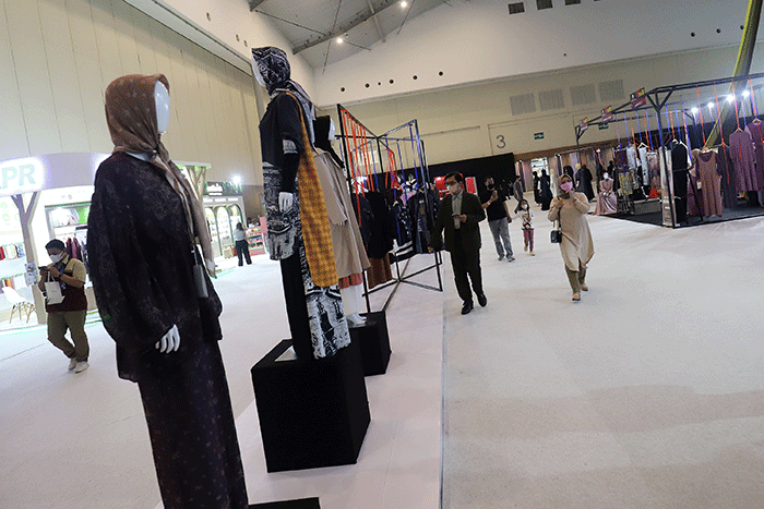 Pengunjung mengamati baju yang dipamerkan saat Jakarta Muslim Fashion Week (JMFW) 2023 di ICE, BSD City, Banten, Kamis (20/10/2022).