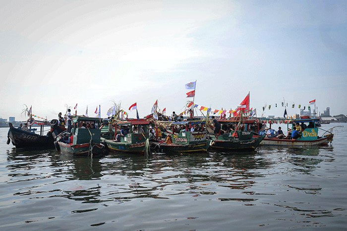 Sejumlah warga mengikuti proses pelepasan sesaji ke laut saat tradisi Nadran Pesta Laut atau Festival Kampung Nelayan di Cilincing, Jakarta Utara.