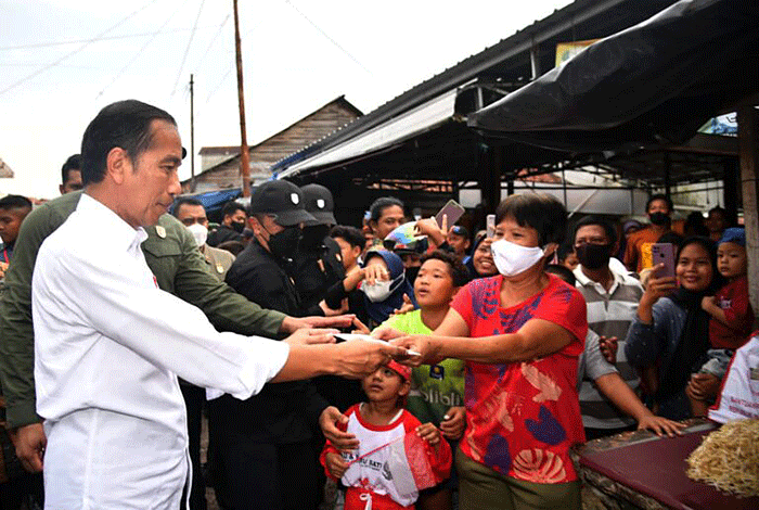 Presiden Joko Widodo menyapa sekaligus menyerahkan bantuan sosial kepada para penerima manfaat di Pasar Toboali, Kabupaten Bangka Selatan.