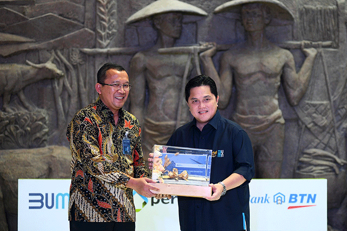 Direktur Utama Bank BTN Haru Koesmahargyo (kiri) memberikan Buku Kajian Perumahan kepada Menteri BUMN Erick Thohir saat peluncuran Festival KPR Hunian Pemuda.