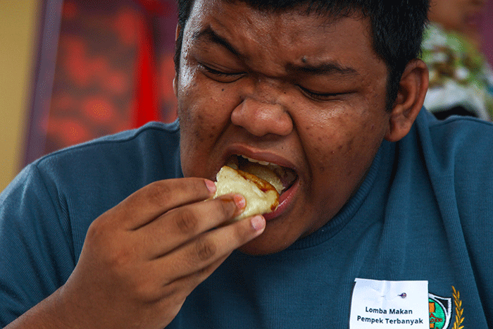 Pelajar yang menjadi peserta lomba makan pempek dos adu cepat dan banyak menghabiskan 10 buah pempek yang disiapan panitia dengan waktu 60 detik.