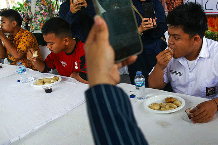 Pelajar yang menjadi peserta lomba makan pempek dos adu cepat dan banyak menghabiskan 10 buah pempek yang disiapan panitia dengan waktu 60 detik.