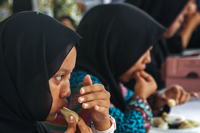 Pelajar yang menjadi peserta lomba makan pempek dos adu cepat dan banyak menghabiskan 10 buah pempek yang disiapan panitia dengan waktu 60 detik.