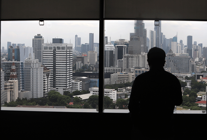 Karyawan melihat gedung bertingkat di kawasan Jakarta Pusat, Selasa (1/11/2022).