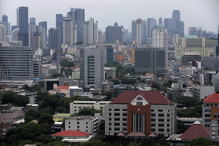Karyawan melihat gedung bertingkat di kawasan Jakarta Pusat, Selasa (1/11/2022).