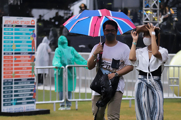 Penonton mengenakan jas hujan saat menyaksikan acara Joyland Festival 2022 di GBK Softball Stadium, Senayan, Jakarta, Jumat (4/11/2022).